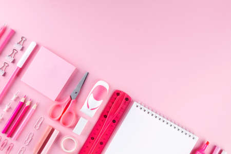 Various school office and painting supplies on pink background. Back to school concept. Geometric and monochrome composition. Top view. Copy spaceの写真素材