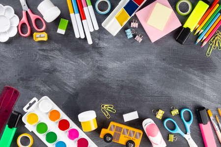 Various school office and painting supplies on black background. Back to school concept. Top view....