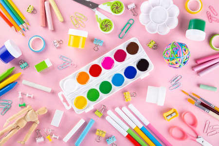 Various school office and painting supplies on pink background. Back to school concept. Top view....