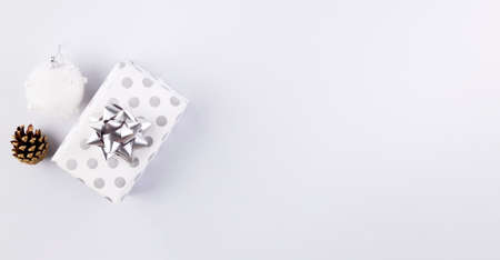 Holiday attributes. Gift in silver packaging on gray background. Top view. Copy spaceの写真素材