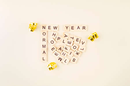 Words New Year and New Normal are laid out in wooden letters, various letters are scattered between them, from which words of support for next year are compiledの写真素材