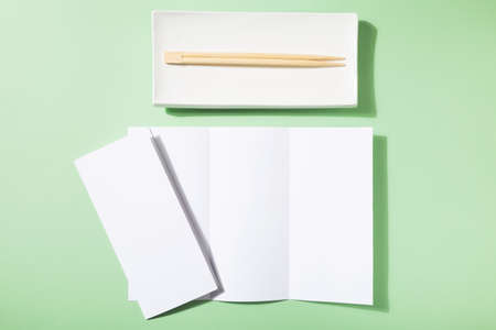 Mockup asian cuisine restaurant menu or brochure, sushi plate and food sticksの写真素材