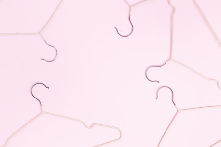 Creative flat lay hangers pastel pink background. Sale discount store promo shopping concept. top view. copy spaceの写真素材