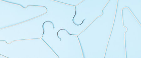 Creative flat lay hangers pastel blue background. Sale discount store promo shopping concept. top...