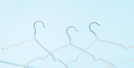 Creative flat lay hangers pastel blue background. Sale discount store promo shopping concept. top viewの写真素材
