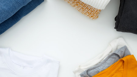 Reduce and reuse concept. Preparing clothes for swap. Waste problem in the fashion industry. Vertical storage of clothing, tidying up, garments declutter and sorting. top view. copy spaceの写真素材