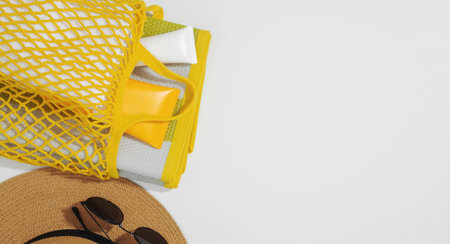 String bag with things for beach towel, sunscreens, hat and sunglasses. Safe exposure to sun. Skin...