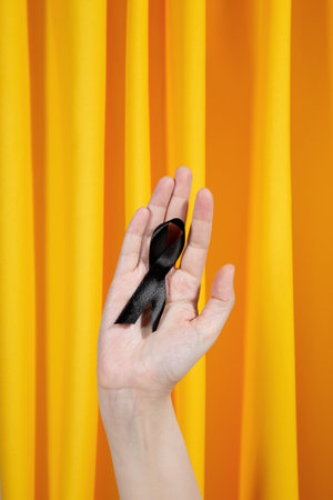 Woman holding black ribbon. Skin Cancer Awareness Month Concept. health careの写真素材