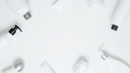 Cosmetic beauty products on white background. Bottles and tubes with branding mock up. Skin care and beauty concept. Top view, flat lay, copy space, frame bannerの写真素材
