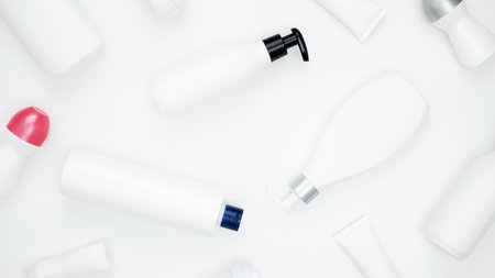 Cosmetic beauty products on white background. Bottles and tubes with branding mock up. Skin care and beauty concept. Top view, flat lay, copy spaceの写真素材