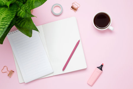 Creative flat lay mockup design of workspace. Top view composition with white notebook, to do list, cup coffee, succulents and stationery on pink backgroundの写真素材