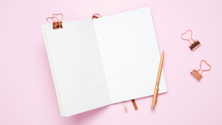 Creative flat lay mockup design of workspace. Top view composition with white notebook, to do list and stationery on pink backgroundの写真素材