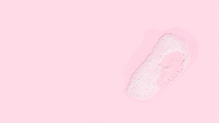 Skincare cleanser foam texture on pink background. Cleansing mousse bubbles for face swatch. face wash later closeupの写真素材
