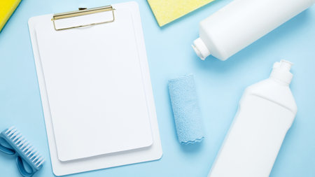 Various accessories cleaning products, rags, sponges and brushes. Mock up white clipboard. Top view,...