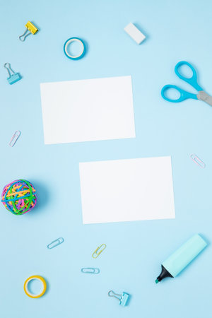 Mockup white papers and set of stationery for work and study on blue background. Back to school. Top view, flat lay, copy spaceの写真素材