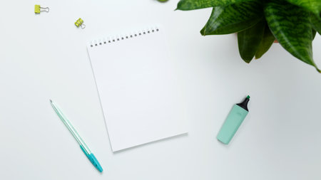 Creative flat lay mockup design of workspace. Top view composition with white notebook, succulents and stationery on white backgroundの写真素材