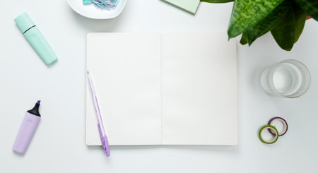 Creative flat lay mockup design of workspace. Top view composition with white notebook, succulents and stationery on white backgroundの写真素材