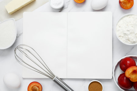 Ingredients for making classic cake pie with plums on white background. Concept homemade food, seasonal pastries. Mock up notebook. Top view, copy spaceの写真素材