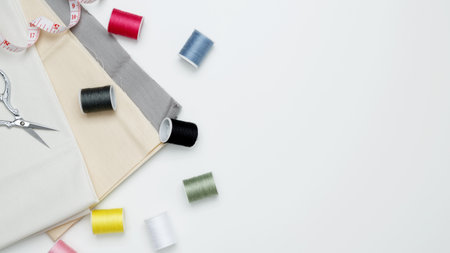 Composition with various threads and sewing accessories on white background. Top view, copy space