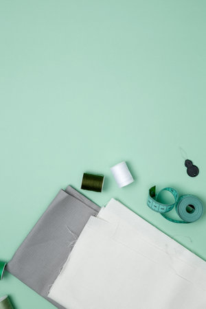 Composition with various threads and sewing accessories on green background. Top view, copy spaceの写真素材
