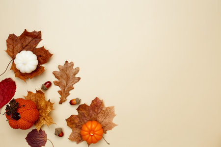 Autumn composition with maple leaves, decorative pumpkins and candles. Top view. Copy space