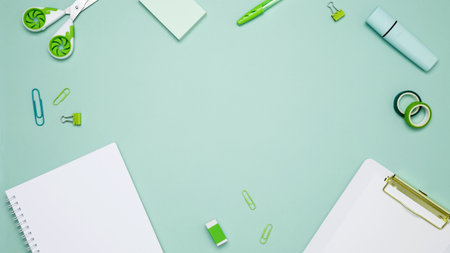 Creative flat lay mockup design of workspace. Top view composition with white notebook, to do list and stationery on green backgroundの写真素材