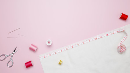 Composition with various threads and sewing accessories on pink background. Top view, copy space