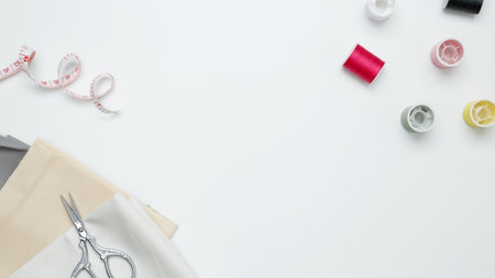 Composition with various threads and sewing accessories on white background. Top view, copy space