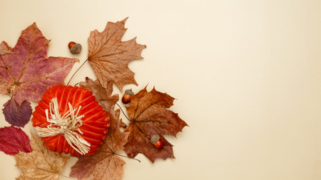 Autumn composition with maple leaves, decorative pumpkins and candles. Top view. Copy space