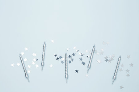 Blank card surrounded by confetti and candle. Concept of festive birthday celebrationsの写真素材