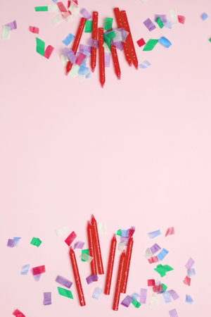 Blank card surrounded by confetti and candle. Concept of festive birthday celebrationsの写真素材