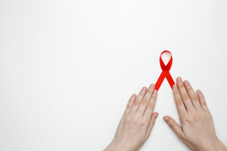 Woman holding red AIDS awareness ribbon. World AIDS Day