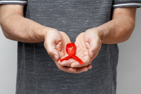 Man holding red AIDS awareness ribbon. World AIDS Dayの写真素材
