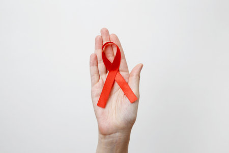 Woman holding red AIDS awareness ribbon. World AIDS Day