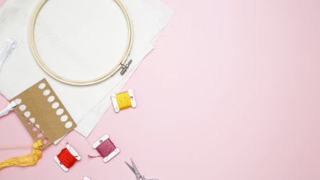 Beige cotton cloth in embroidery hoop with fabric, colorful threads, scissors and needles....