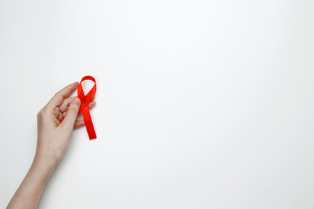 Woman holding red AIDS awareness ribbon. World AIDS Day