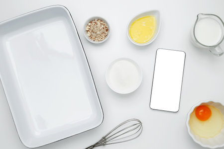 Cooking ingredients and smartphone with blank screen on a white background. Mockup design for recipe...