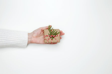 Woman's hand holding a wrapped gift, symbolizing celebration, giving, and thoughtful gestureの写真素材