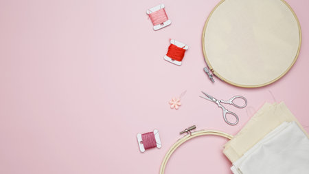 Beige cotton cloth in embroidery hoop with fabric, colorful threads, scissors. Embroidery set for...