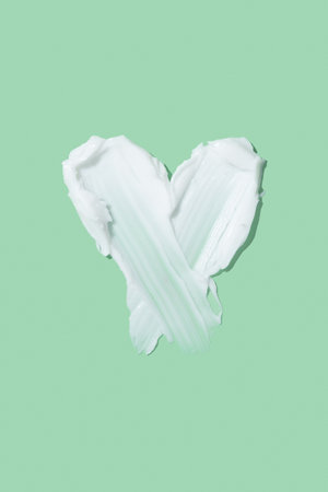 White beauty cream smear smudge isolated. Beauty skincare cream texture swipe swatch in heart shapedの写真素材