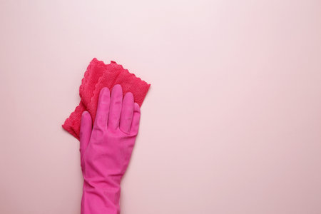 Pink cleaning products, the woman cleans using rubber gloves and a microfiber cloth. Household cleaning and hygiene conceptの写真素材