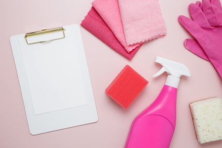 Pink cleaning supplies including rubber gloves, spray bottle, microfiber cloths. Household cleaning and hygiene concept. Mock up clipboardの写真素材