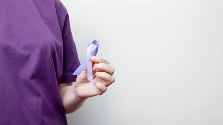 Purple ribbon held by a person in a purple shirt, symbol of support. Purple Epilepsy Awareness Dayの写真素材