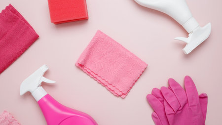 Household cleaning and hygiene concept. Pink cleaning supplies including rubber gloves, spray bottle, sponge, microfiber clothsの写真素材