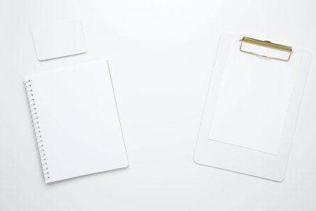 On a white background, an empty mock up notebook and clipboard, white and black cardsの写真素材