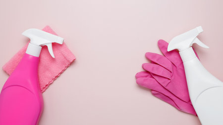Household cleaning and hygiene concept. Pink cleaning supplies including rubber gloves, spray bottles, microfiber clothsの写真素材