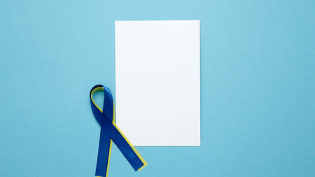 White notebook mockup. A yellow and blue awareness ribbon, symbolizing World Down Syndrome Dayの写真素材