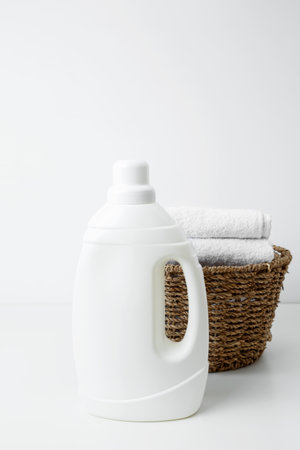 Laundry detergent mock up and basket filled with clean white towels. Household cleaning and hygiene concept packagingの写真素材