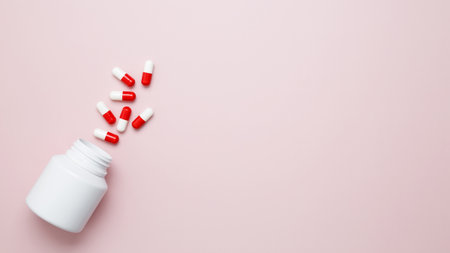Concept of healthcare and medicine. White bottle container with colorful medication capsules and tabletsの写真素材