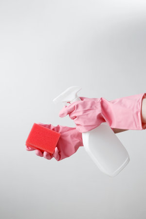 Household cleaning and hygiene concept. Womans hand in holds pink dishwashing sponge and cleaning productの写真素材